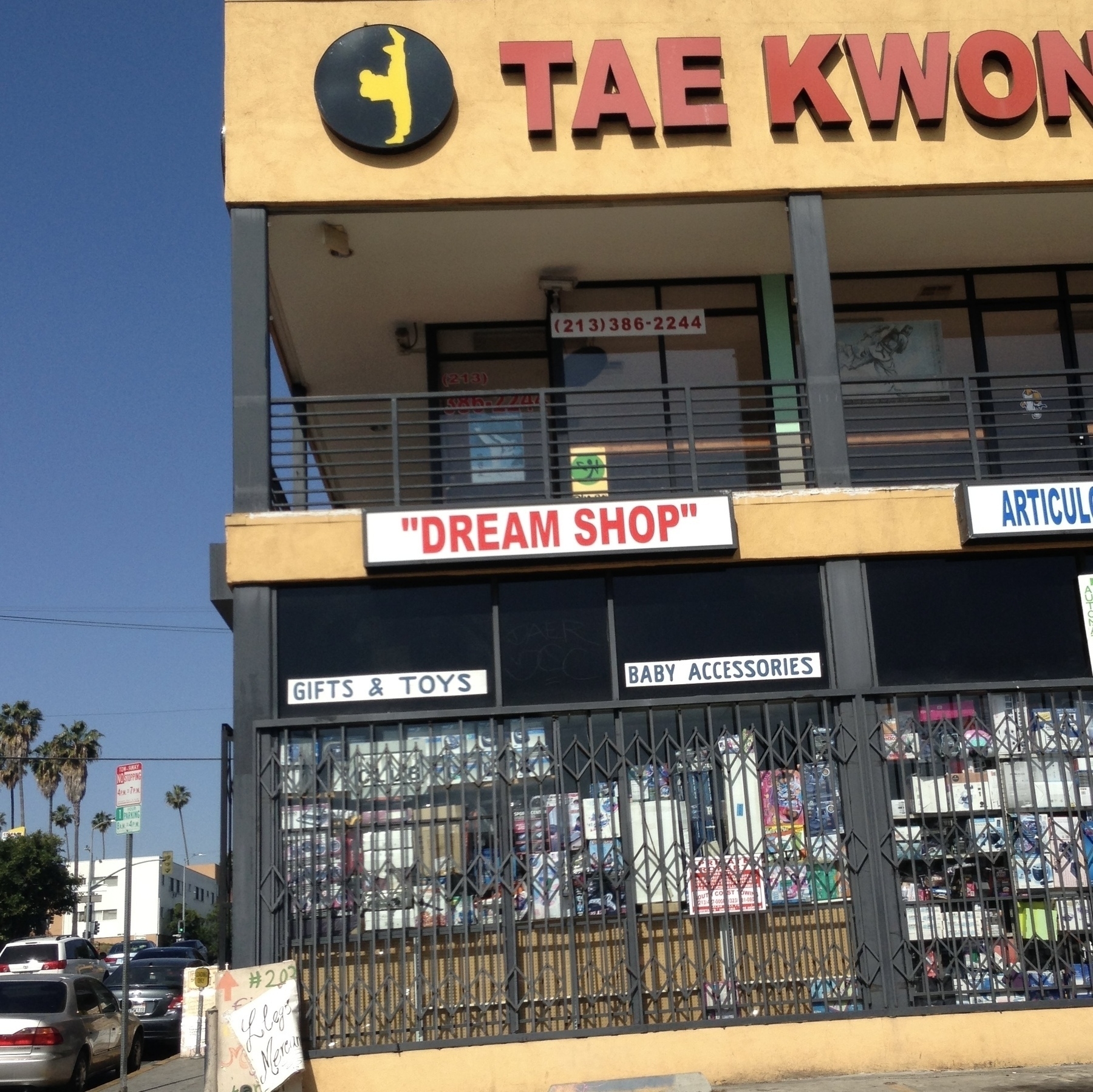 A typical Los Angeles two story retail plaza with a store called DREAM SHOP in red capital letters and in quotes.