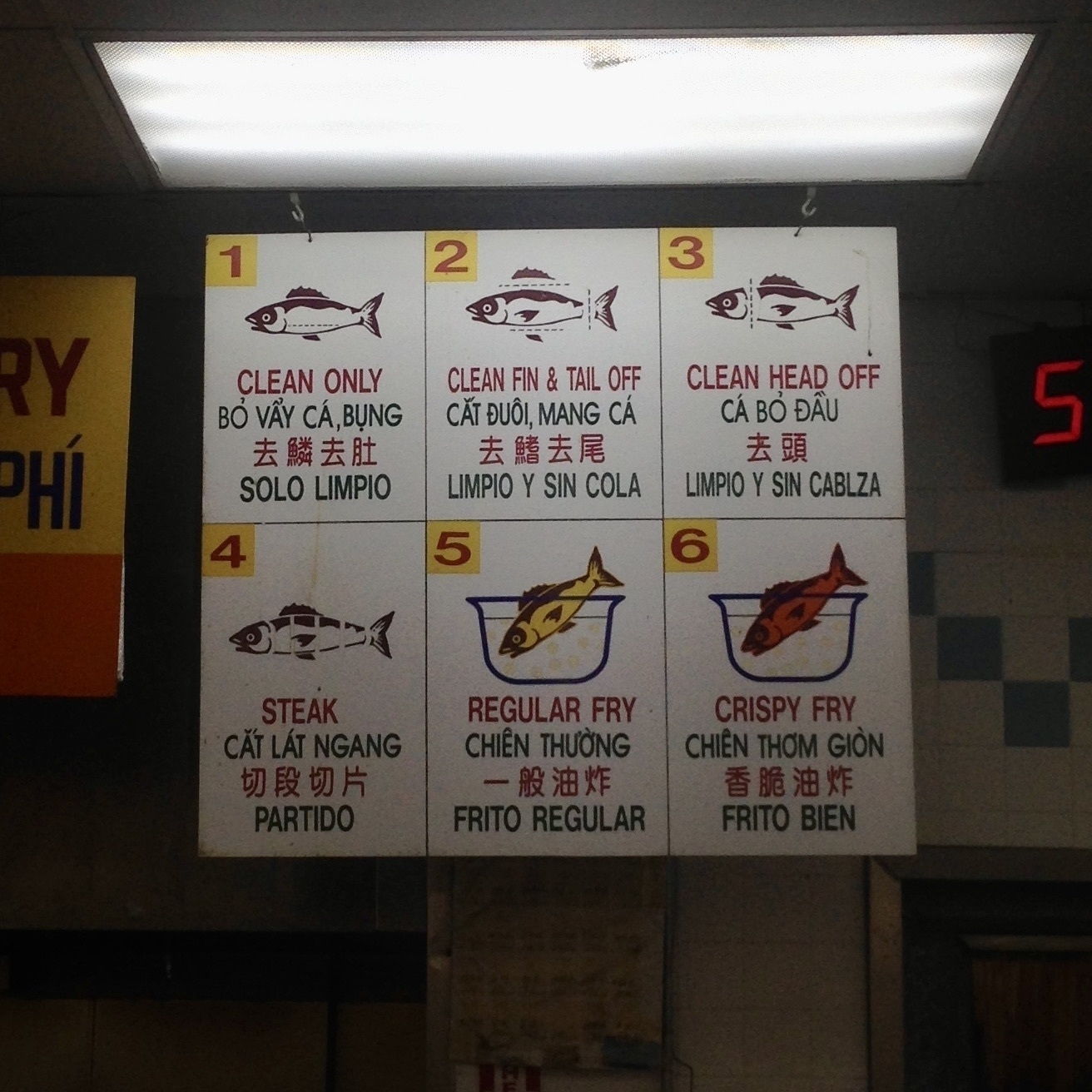A sign at a supermarket seafood counter shows 6 preparation options in English, Vietnamese, Chinese, and Spanish. Option 6 is 'Crispy Fry'.